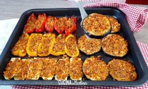Delizioso piatto di verdure gratinate al forno: peperoni rossi e gialli ripieni, zucchine a rondelle e melanzane a fette, tutti dorati e croccanti.