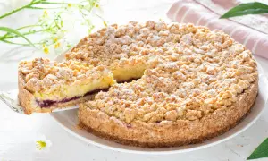 Deliziosa sbriciolata alla crema con un ripieno di marmellata di frutti di bosco, cosparsa di zucchero a velo.