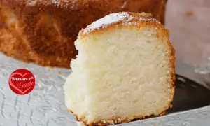 Una fetta di torta senza glutine, soffice e dorata, cosparsa di zucchero a velo. Un piacere per il palato e per il benessere.