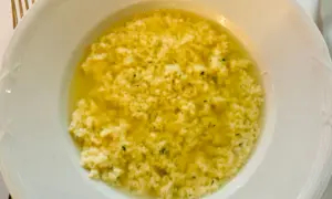 Stracciatella alla romana in una ciotola bianca, un piatto caldo e confortante con uova, parmigiano e prezzemolo.