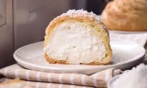 Bignè ripieno di crema, cosparso di zucchero a velo che ricorda soffici fiocchi di neve.