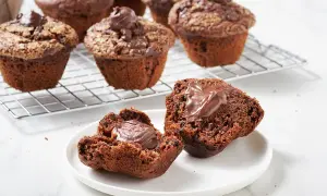 Muffin al cioccolato soffici e golosi, uno aperto rivela un cuore cremoso. Perfetti per una pausa dolce.