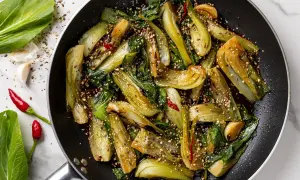 Pak choi saltato in padella con aglio, peperoncino e semi di sesamo. Un'idea veloce per gustose ricette in padella.