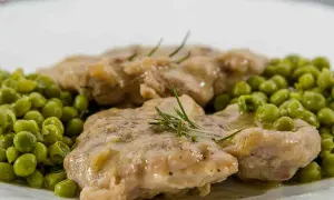 Ossobuco con piselli, un piatto succulento con carne tenera e piselli freschi, guarnito con rosmarino.