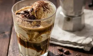 Un delizioso affogato al caffè, con gelato alla vaniglia, cacao e scaglie di cioccolato, pronto per essere gustato.