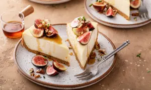 Delizioso cheesecake ai fichi, guarnito con fichi freschi, noci e miele dorato.