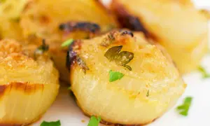 Cipolla al forno intera, dorata e profumata, con erbe aromatiche fresche. Un contorno semplice e gustoso.