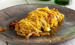 Un piatto di spaghetti con funghi e una cremosa salsa gialla, un esempio di ricette pasta gustose che invitano a scoprire nuovi sapori.