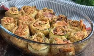 Involtini di zucchine al forno, dorati e croccanti, ripieni e gratinati, pronti per essere gustati.
