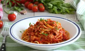Un piatto di spaghetti al tonno, un classico della cucina di Vane, con pomodorini freschi e prezzemolo.
