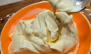 Una ciotola arancione piena di soffice crema al mascarpone, pronta per essere gustata.