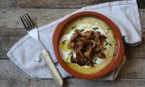 Polenta cremosa con funghi finferli saltati, un piatto rustico e saporito.