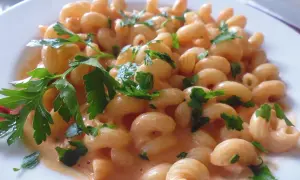 Un piatto invitante di pasta al limone cremosa, guarnita con prezzemolo fresco.