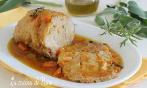 Arrosto di vitello morbido con sughetto benedetta, profumato con erbe aromatiche e carote. Un piatto succulento che invita a gustare ogni fetta.