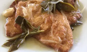 Bistecche in carpione dorate e succulente, condite con cipolle, salvia e aglio in una salsa profumata.