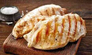 Petto di pollo grigliato, perfetti secondi di carne da preparare in anticipo. Un contorno di sale completa l'immagine.