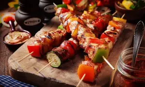 Spiedini di carne succulenti con peperoni, zucchine e pomodori, pronti per essere gustati.