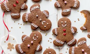 Biscotti di pan di zenzero decorati con glassa bianca e cuoricini rossi, pronti per essere gustati.