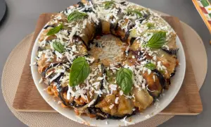 Anelletti al forno alla siciliana con melanzane, un piatto invitante con pasta, melanzane, formaggio grattugiato e basilico fresco.