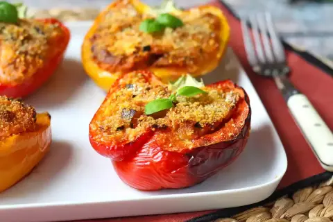 Peperoni al forno ripieni, colorati e invitanti, guarniti con basilico fresco.