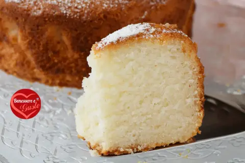 Una fetta di torta senza glutine, soffice e dorata, cosparsa di zucchero a velo. Un piacere per il palato e per il benessere.