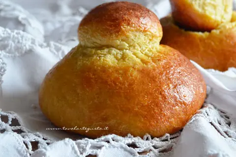 Brioche col tuppo dorate e soffici, pronte per essere gustate.