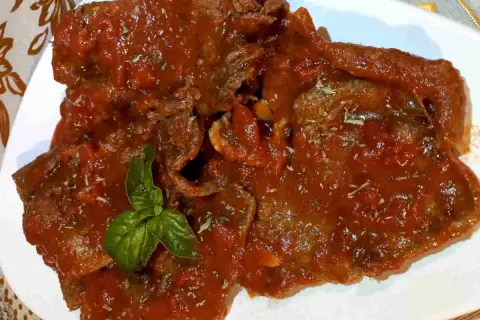 Deliziosa carne alla pizzaiola, tenera e succulenta, immersa in un ricco sugo di pomodoro e basilico fresco.