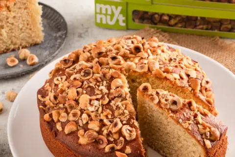Delizioso dolce con banane e nocciole tostate, una fetta è già servita.
