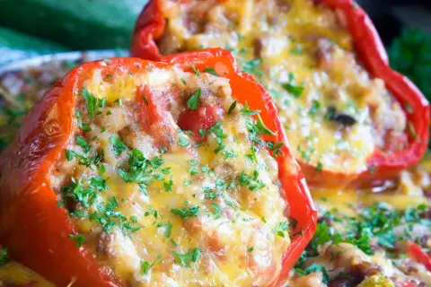 Peperoni ripieni senza carne, dorati e filanti, guarniti con prezzemolo fresco. Un piatto gustoso e colorato.