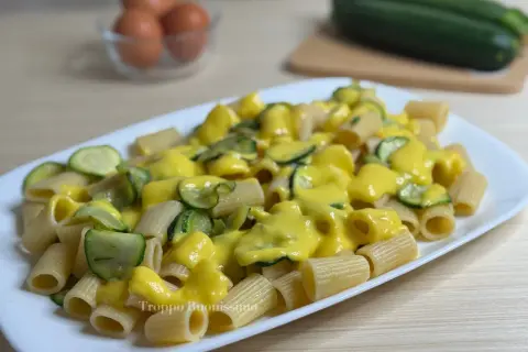 Piatto di rigatoni conditi con una cremosa salsa gialla e zucchine a rondelle. Una deliziosa carbonara di zucchine pronta da gustare.