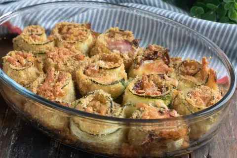 Involtini di zucchine al forno, dorati e croccanti, ripieni e gratinati, pronti per essere gustati.