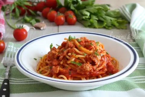 Un piatto di spaghetti al tonno, un classico della cucina di Vane, con pomodorini freschi e prezzemolo.