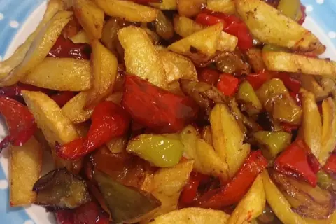 Un gustoso contorno di patate fritte e peperoni colorati, un classico piatto di pipi e patate.