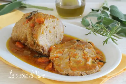 Arrosto di vitello morbido con sughetto benedetta, profumato con erbe aromatiche e carote. Un piatto succulento che invita a gustare ogni fetta.