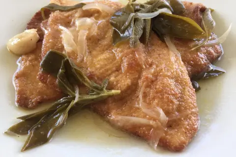 Bistecche in carpione dorate e succulente, condite con cipolle, salvia e aglio in una salsa profumata.