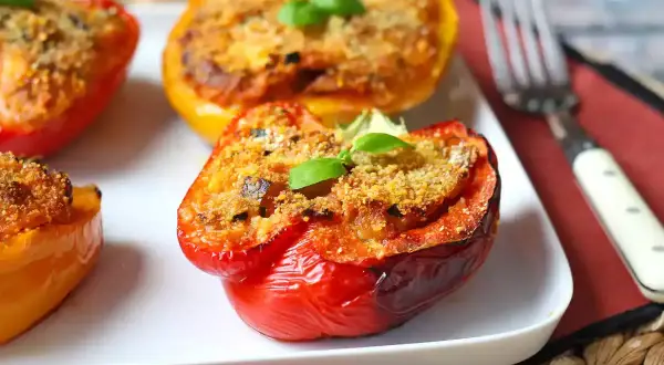 Peperoni al forno ripieni, colorati e invitanti, guarniti con basilico fresco.