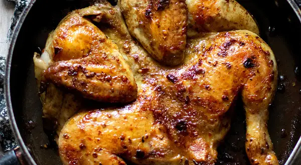 Pollo alla diavola succulento e dorato, cotto in padella con spezie piccanti. Un piatto invitante e saporito.
