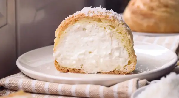 Bignè ripieno di crema, cosparso di zucchero a velo che ricorda soffici fiocchi di neve.
