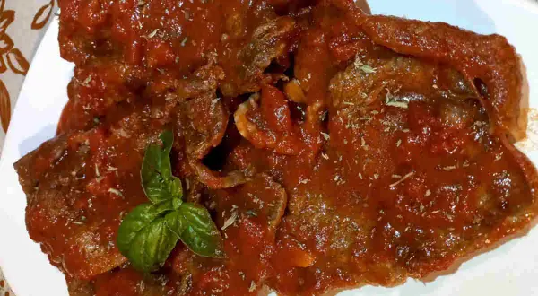 Deliziosa carne alla pizzaiola, tenera e succulenta, immersa in un ricco sugo di pomodoro e basilico fresco.