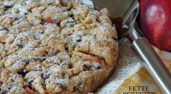 Torta sbriciolata con pesche e gocce di cioccolato, perfetta per chi ama le ricette con le pesche. Un dolce rustico e goloso.