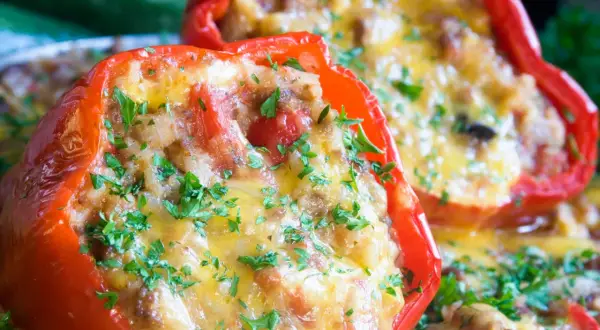 Peperoni ripieni senza carne, dorati e filanti, guarniti con prezzemolo fresco. Un piatto gustoso e colorato.