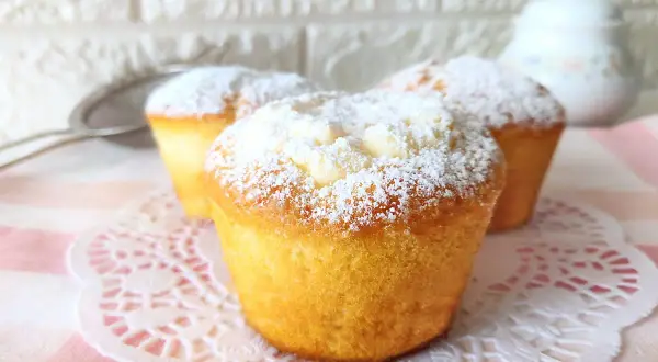 Muffin soffici e dorati, spolverati di zucchero a velo, perfetti per una ricetta facile e golosa.