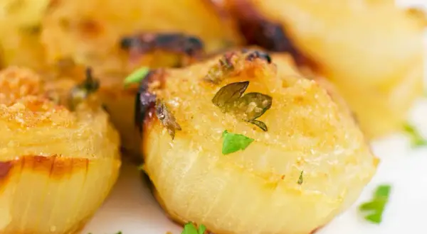 Cipolla al forno intera, dorata e profumata, con erbe aromatiche fresche. Un contorno semplice e gustoso.