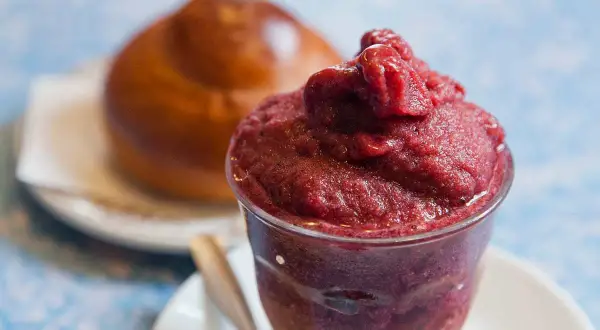 Brioche soffice con una generosa porzione di gelato ai frutti di bosco, un'accoppiata perfetta per una pausa golosa.