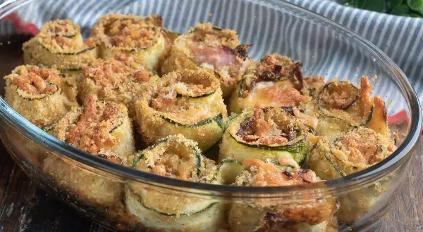 Involtini di zucchine al forno, dorati e croccanti, ripieni e gratinati, pronti per essere gustati.