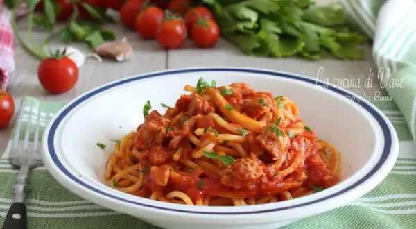 Un piatto di spaghetti al tonno, un classico della cucina di Vane, con pomodorini freschi e prezzemolo.