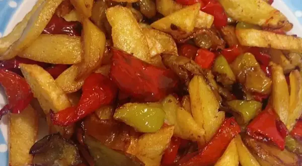 Un gustoso contorno di patate fritte e peperoni colorati, un classico piatto di pipi e patate.