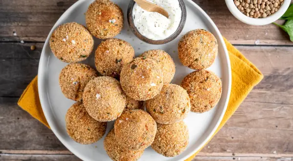 Polpette dorate e croccanti, perfette per le tue ricette con lenticchie. Servite con una ciotolina di salsa cremosa.