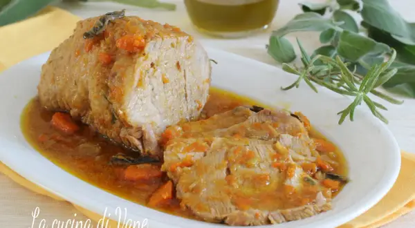 Arrosto di vitello morbido con sughetto benedetta, profumato con erbe aromatiche e carote. Un piatto succulento che invita a gustare ogni fetta.