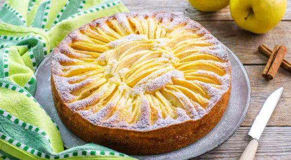 Una deliziosa torta di mele light, decorata con fettine di mela e zucchero a velo, pronta per essere gustata.